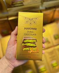Hand holding a Mardini chocolate bar packaging with a blurred background